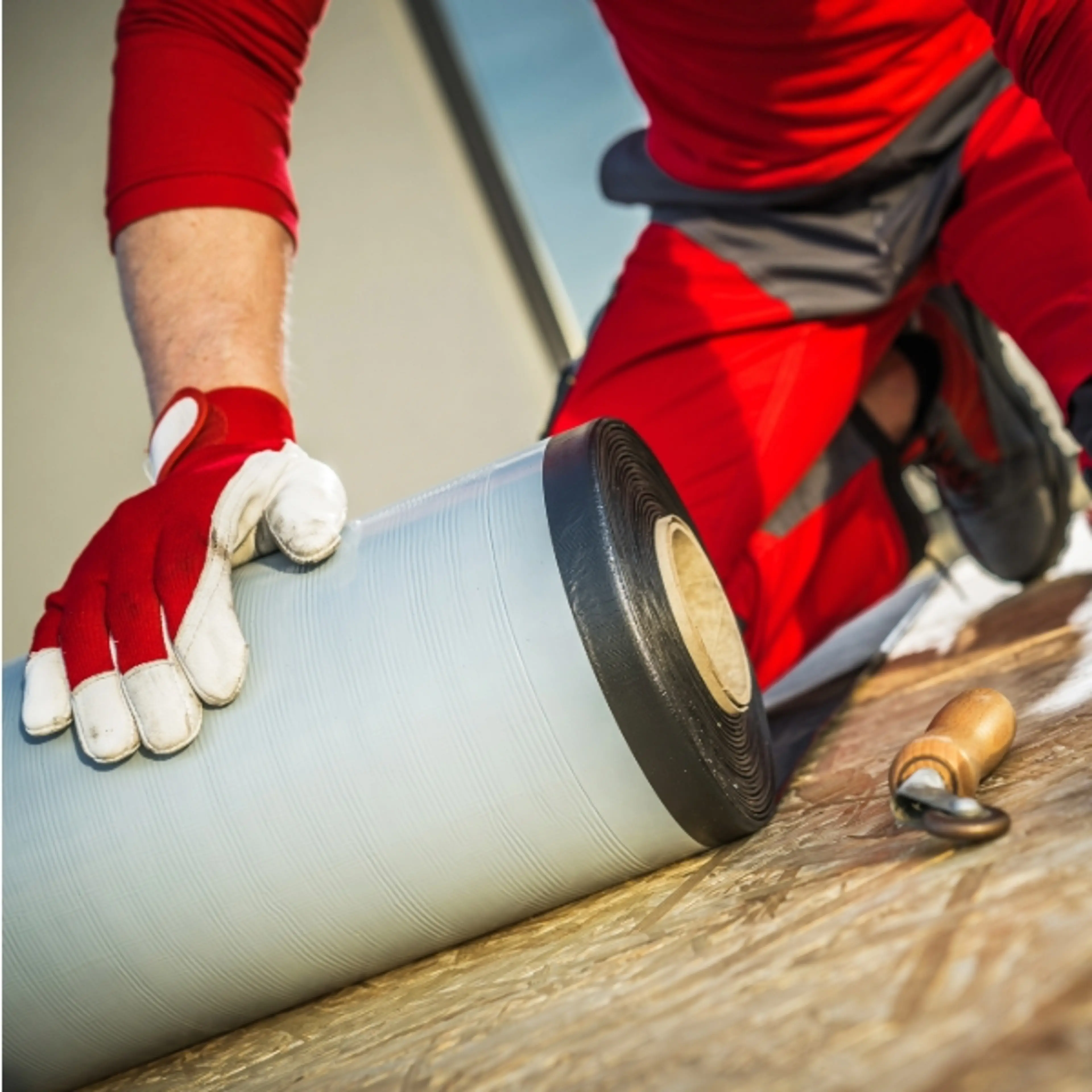 Image of man installing waterproof membrane roofing