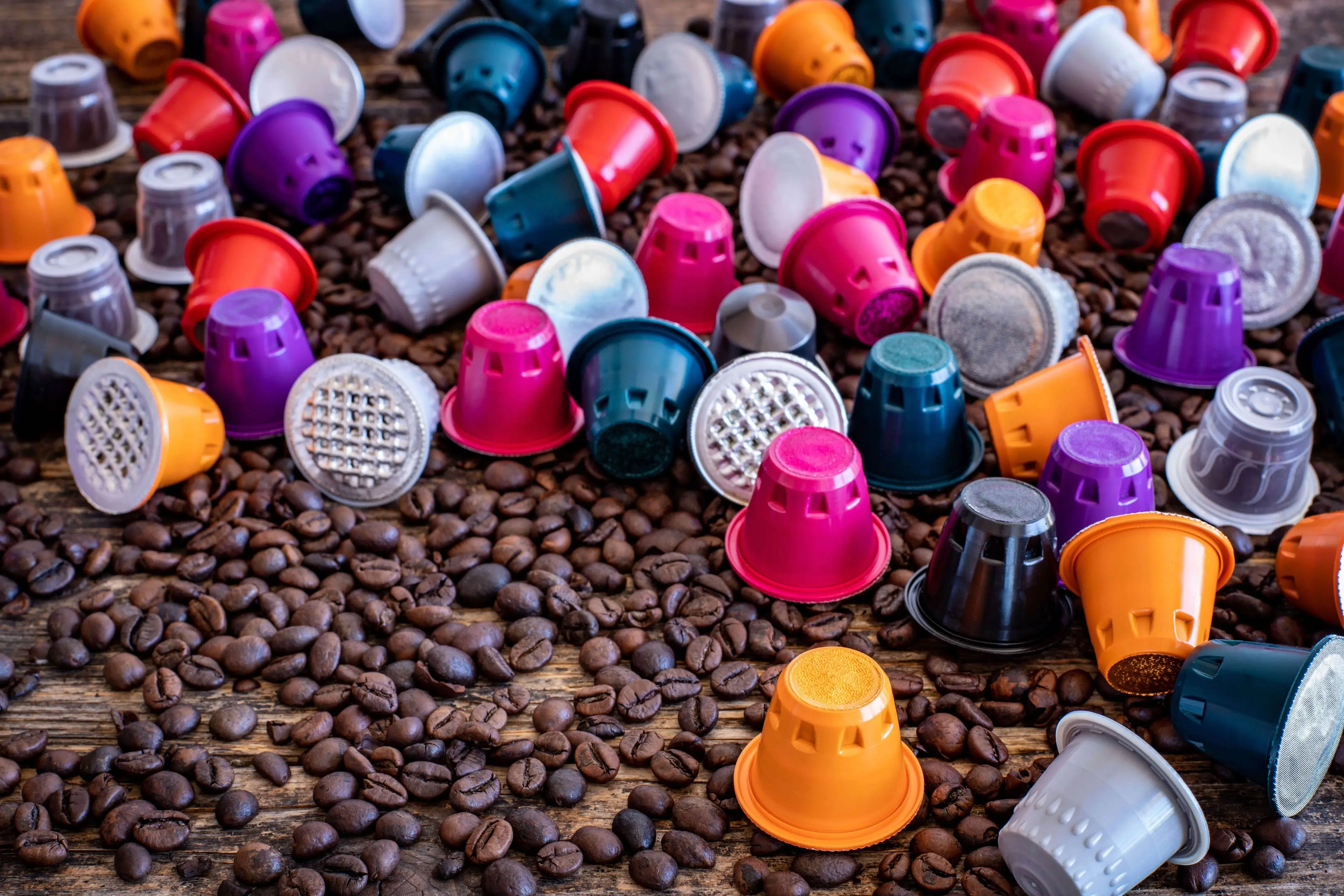 coffee capsules and beans on a wooden table