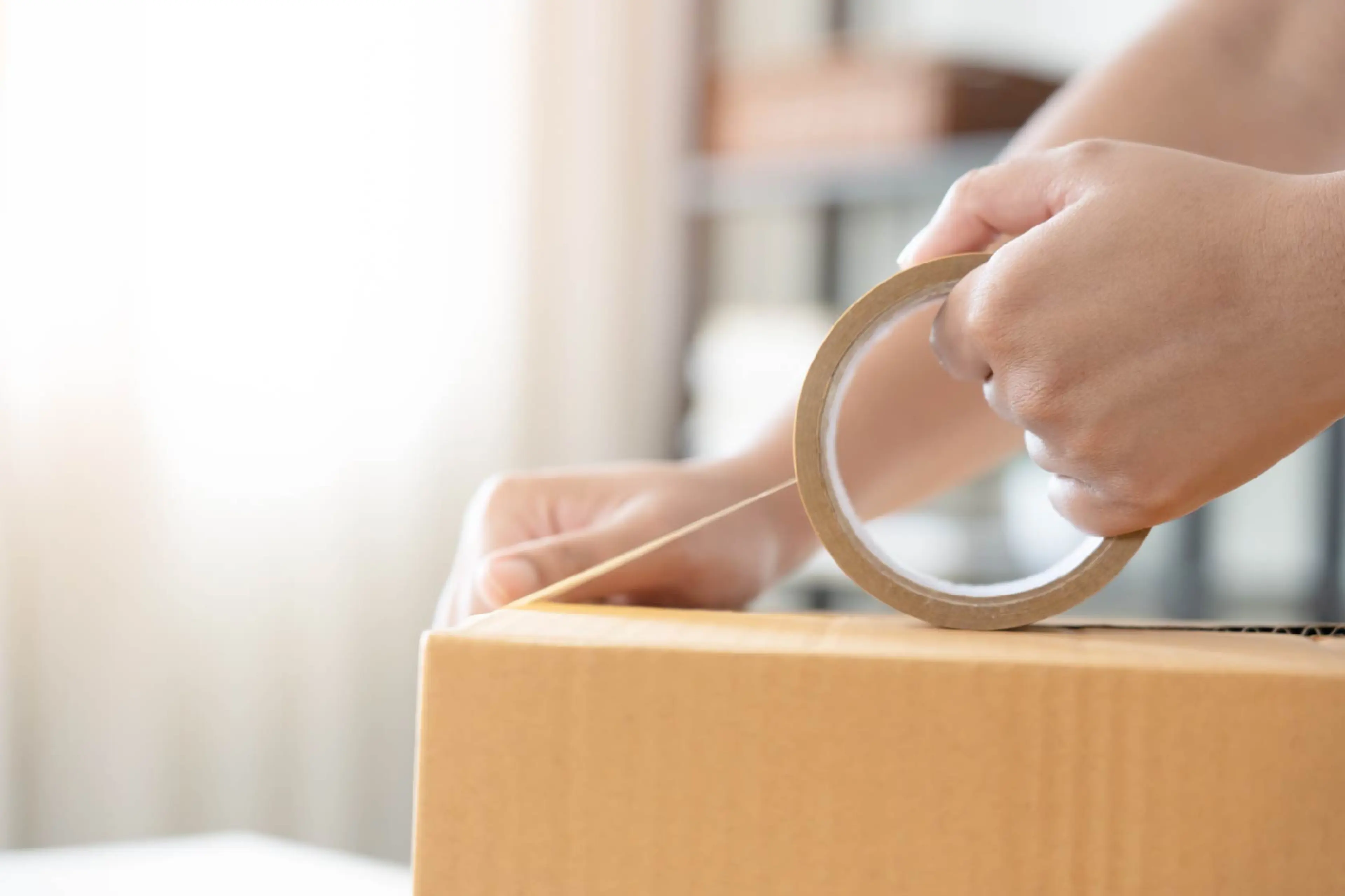 Person using biax film tape to pack box