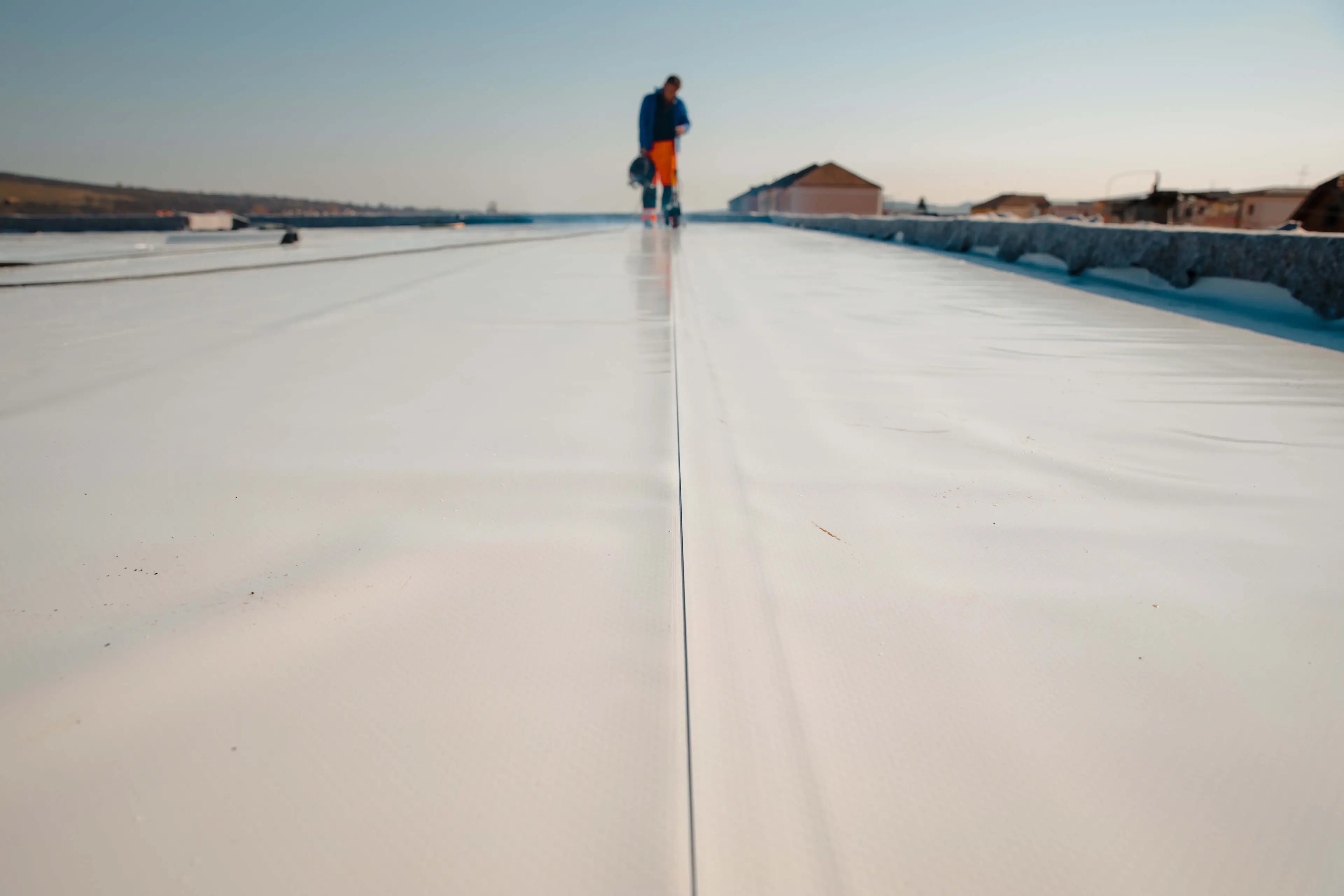 A man laying waterproof roofing membrane